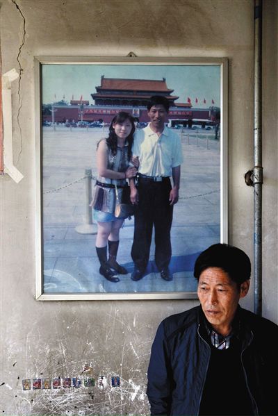 11月14日，承德市平泉縣，潘小梅父母的家，潘小梅父親靠在墻上，身后掛著數(shù)年前他和潘小梅在北京的合影照片。新京報(bào)記者
