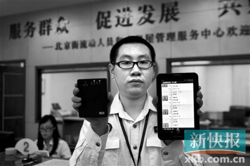 　越秀區(qū)北京街出租屋外來(lái)暫住人員管理服務(wù)中心的工作人員展示到出租屋登記來(lái)穗人員信息的儀器。