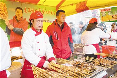 賣(mài)羊肉串?dāng)偽焕习遐w山（穿紅衣者）。新京報(bào)記者