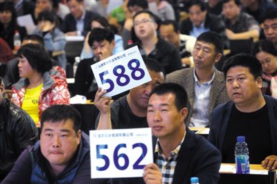 昨日，拍賣現(xiàn)場競拍者舉牌競拍。新京報(bào)記者