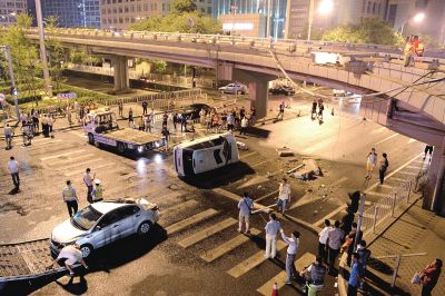 路虎沖下國貿(mào)橋砸中一輛起亞轎車，橋上厚達幾十厘米的水泥護欄被撞斷，碎石四處散落，數(shù)十群眾在現(xiàn)場圍觀。