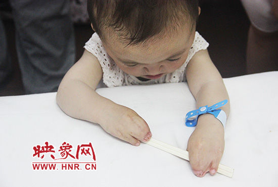 孩子握著筷子發(fā)呆。