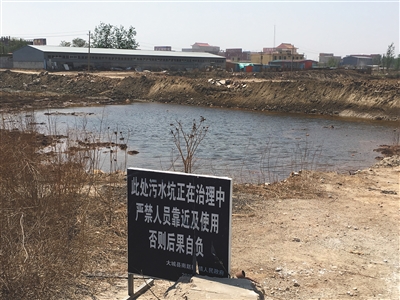 化肥廠滲坑的三分之一經(jīng)過治理，但水質(zhì)仍然呈黃褐色。