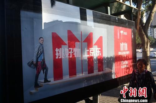 資料圖：11月1日，福州民眾從雙十一廣告牌前經(jīng)過。中新社記者 呂明 攝