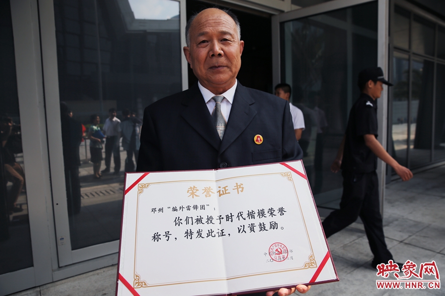 河南鄧州“編外雷鋒團(tuán)”團(tuán)長宋清梅向眾多記者展示中宣部授予的“時(shí)代楷?！睒s譽(yù)證書。