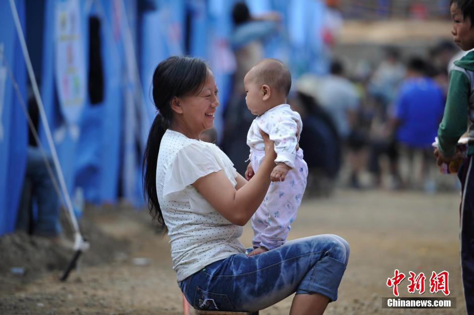 8月6日，一名年輕的母親在和孩子玩樂(lè)。