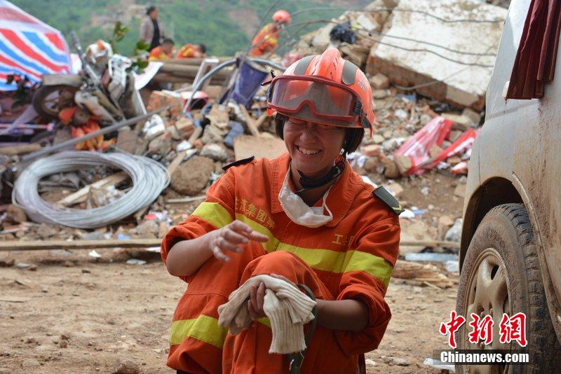 2014年8月5日，女兵在云南魯?shù)辇堫^山鎮(zhèn)廢墟中搜救被困者。