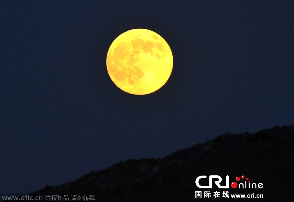 8月10日晚，一輪金燦燦的大月亮在遼寧省大連市東方升起。圖片來源：劉德斌/東方IC