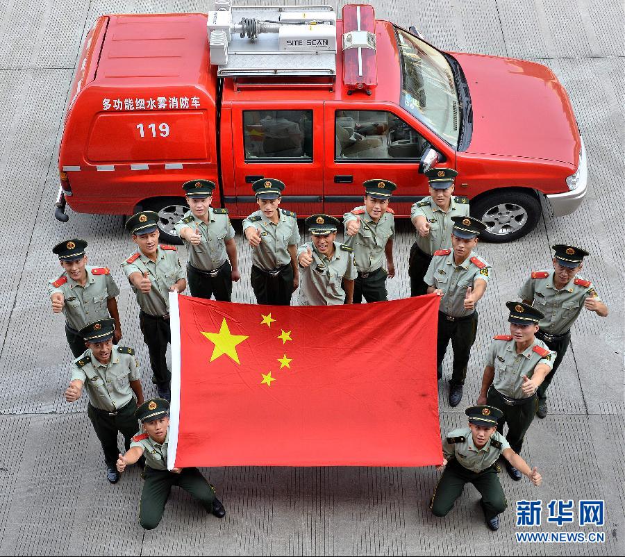 9月25日，武警浙江嘉興消防官兵與國(guó)旗合影。