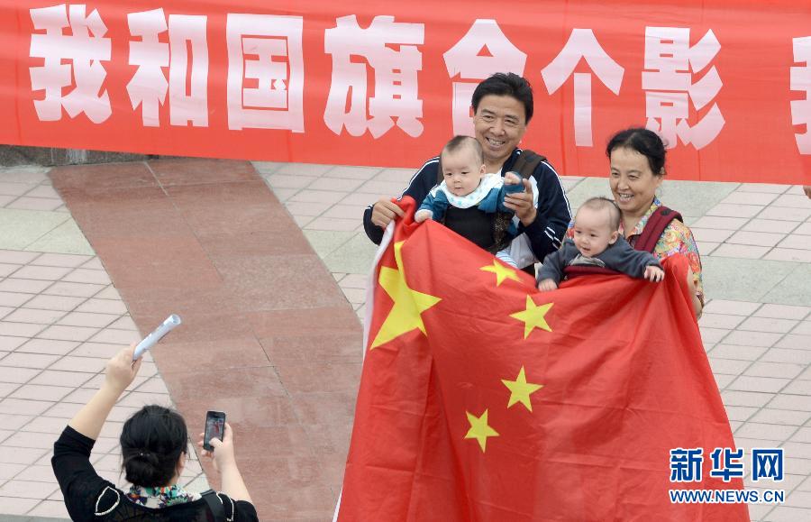 9月27日，在山東德州市中心廣場(chǎng)，市民與國(guó)旗合影。
