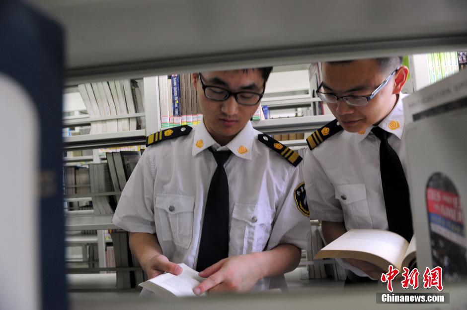 5月8日，武漢輕工大學(xué)圖書館保安吳濤與江力在圖書館交流學(xué)習(xí)。