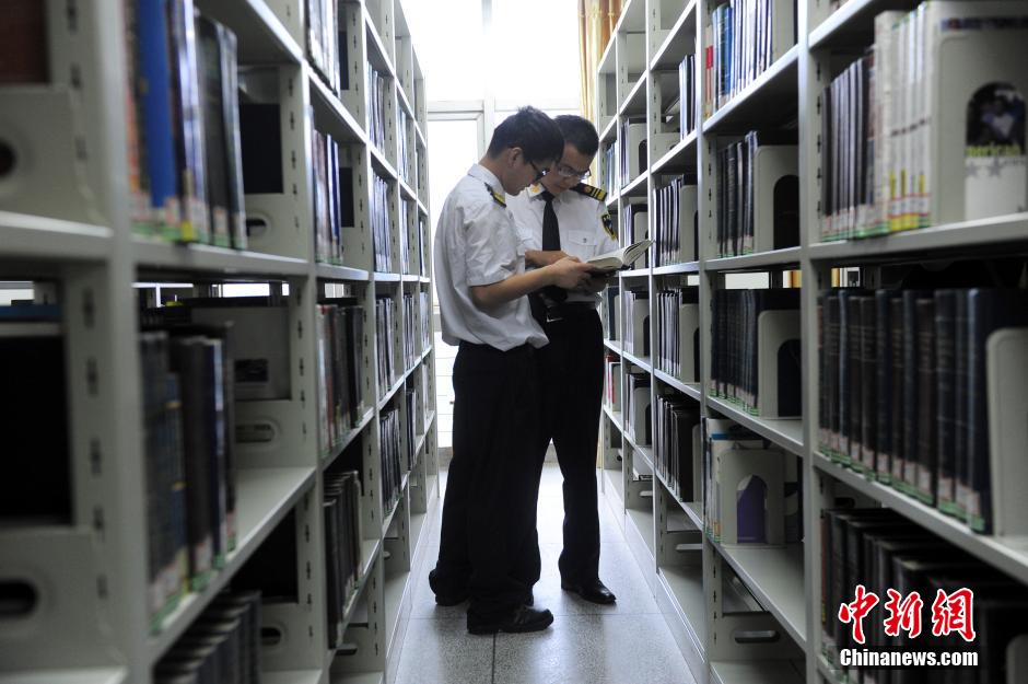 5月8日，武漢輕工大學(xué)保安吳濤與江力在圖書館交流學(xué)習(xí)。中新社發(fā) 張暢 攝