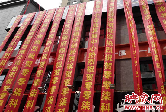 路邊一棟樓上懸掛著二三十條紅色條幅，全部是祝賀一家公司開業(yè)的。