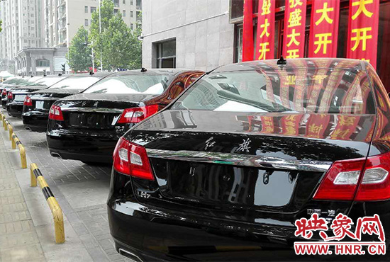 路邊一棟樓上懸掛著二三十條紅色條幅，全部是祝賀一家公司開業(yè)的。