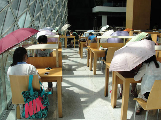 2015年8月2日，深圳圖書館，“太陽曬進(jìn)來很熱的，我們都要撐著傘讀書?！? complete=