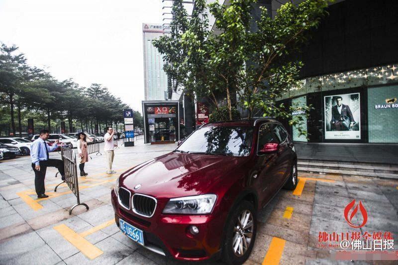 一輛停在停車位上的寶馬轎車，被墜落的樹枝砸中，樹枝徑直插入車內(nèi)，現(xiàn)場(chǎng)引發(fā)不少市民圍觀拍照。