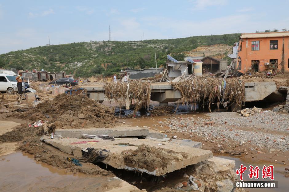 圖為洪水過后，坍塌的橋梁上遺落大量雜草。