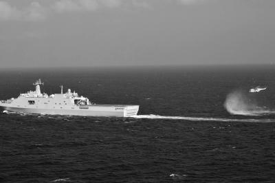 11日，抵達馬航飛機失聯(lián)海區(qū)的海軍井岡山艦與艦載直升機協(xié)同展開立體搜救行動。新華社發(fā)