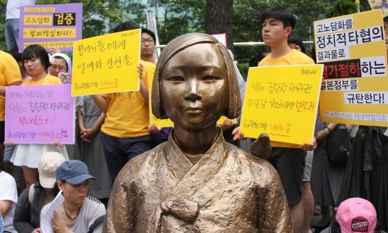 7月2日，在韓國首爾的日本駐韓國大使館前，民眾在慰安婦少女像旁手持標(biāo)語參加抗議活動(dòng)。