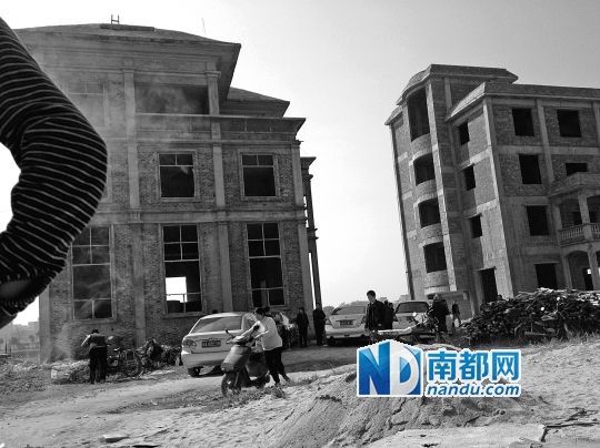 兩棟被舉報(bào)的違建樓下昨日一度聚集了超過百人，城管離開后逐漸散去。南都記者張志韜實(shí)習(xí)生宋超攝