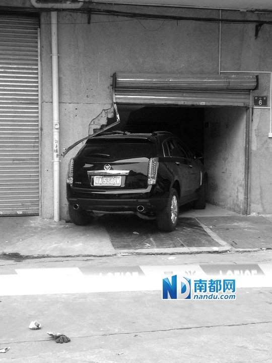 　昨日，凱迪拉克撞人后停在一倉(cāng)庫(kù)門口，車后有一攤血跡。 南都記者陳杰生攝