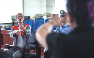 張志國在法庭上用手語回答提問。記者 蒲東峰攝