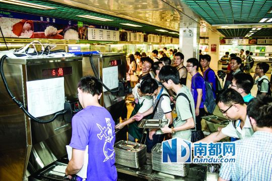 昨日，華南理工大學(xué)一食堂內(nèi)，學(xué)生們正在使用新安裝的自動(dòng)打飯機(jī)打飯。中新社發(fā)