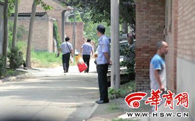 昨日，西安市閻良區(qū)譚家村，警方在事發(fā)的孫某家里勘查現場后，將提取的物證帶走 記者 黃利健 攝