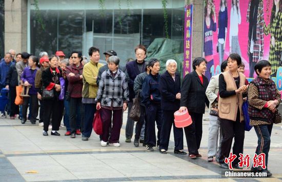 圖為10月28日，在江西九江市一家羊絨皮草服裝服飾博覽會(huì)現(xiàn)場，老人們正在頂著寒風(fēng)排隊(duì)等待領(lǐng)取10元代金劵。