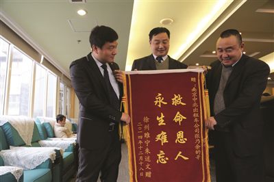 張乃余(中)和兩位救人的同伴一塊領(lǐng)獎。