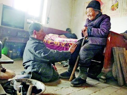52歲的劉蘭山每天靠爬行照顧90歲的老母親。孫國(guó)祥 攝