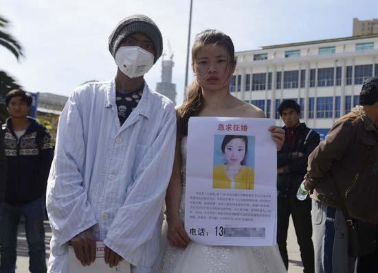 昆明火車站廣場(chǎng)上，24歲的黃習(xí)菊身穿潔白的婚紗，帶著身患白血病的弟弟征婚。