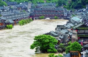 7月16日,沱江兩邊的商鋪和遠(yuǎn)處的虹橋仍淹沒在洪水中。 新華社發(fā)