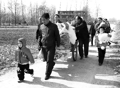 姐（左一）弟（右一護(hù)士懷中男嬰）返鄉(xiāng)，愛心捐贈(zèng)滿滿一架子車。