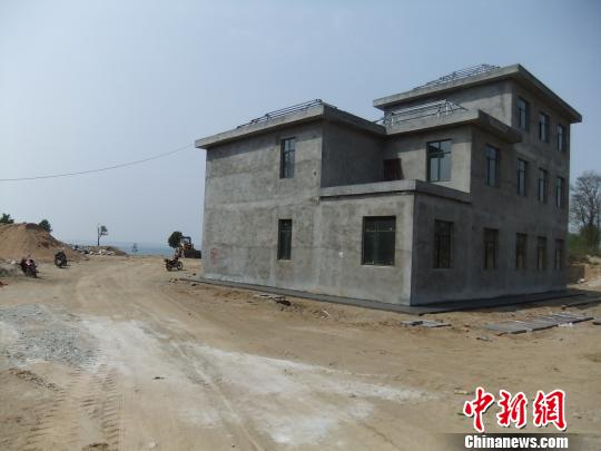 鴨河水庫(kù)庫(kù)區(qū)邊的新建別墅，一面墻上寫著“拆”，另一邊在加緊施工。吳揚(yáng)　攝