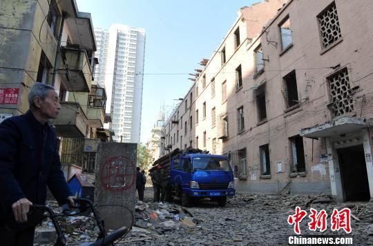 一位花甲老人站在即將拆除的樓房旁，默默地與“蘇聯(lián)樓”告別。　翟羽佳　攝