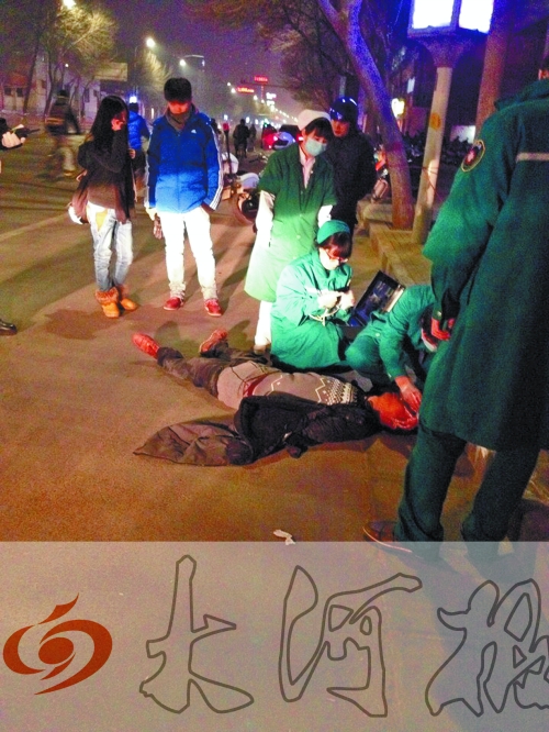 醉漢躺在地上，醫(yī)護(hù)人員對(duì)其進(jìn)行檢查。